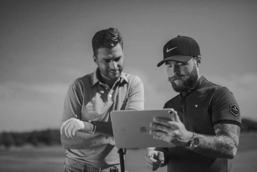 Joueur et coach de golf regardant des données sur un iPad